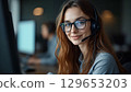 Smiling customer service representative working in busy call center 129653203