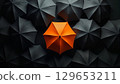Orange umbrella standing out from crowd of black umbrellas 129653211