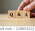 Q and a concept is being created with wooden cubes by human hand 129653212