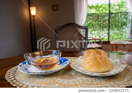 Cream puffs and tea at a cafe table Cream puffs and tea at a cafe table 129653575