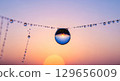 A macro photograph of a single dewdrop on a spiderweb at dawn. Inside the dewdrop, the entire world is reflected in a beautiful, distorted miniature.  129656009