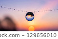 A macro photograph of a single dewdrop on a spiderweb at dawn. Inside the dewdrop, the entire world is reflected in a beautiful, distorted miniature.  129656010