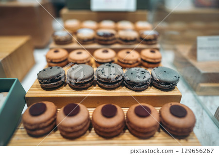 macarons on display in cafe showcasing gourmet variety and sweet indulgence, pastries arranged in bakery highlighting flavorful assortment and tempting elegance macarons on display in cafe showcasing gourmet variety and sweet indulgence, pastries arranged in bakery highlighting flavorful assortment and tempting elegance 129656267