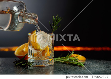 Refreshing gin-tonic cocktail with lemon and rosemary. Refreshing gin-tonic cocktail with lemon and rosemary. 129657127