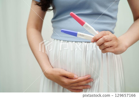 Asian holding pregnancy test for female of ovulation day, fetus, maternity, childbirth, birth control. Asian holding pregnancy test for female of ovulation day, fetus, maternity, childbirth, birth control. 129657166
