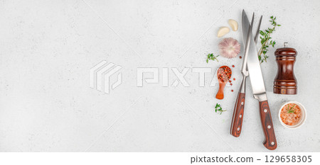 Kitchen utensils and seasonings arranged on a light countertop for culinary preparation. top view. copy space 129658305