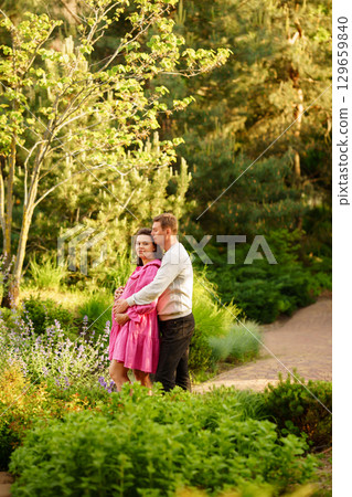 Man gently hugging pregnant woman while sitting in garden at home. Man gently hugging pregnant woman while sitting in garden at home. 129659840