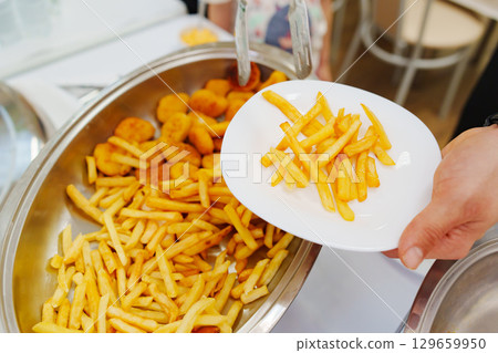 Heated tray with french fries and nuggets. Banquet food delivery. Heated tray with french fries and nuggets. Banquet food delivery. 129659950