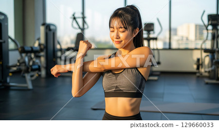 Japanese woman doing stretching exercises at the gym 129660033