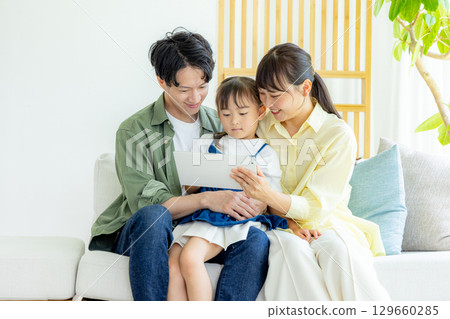 看片劑的年輕家庭在客廳 129660285