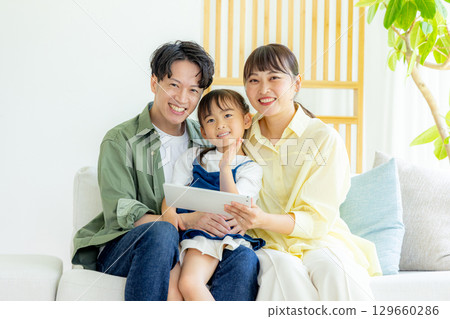 看片劑的年輕家庭在客廳 129660286