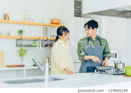 A couple cooking in the kitchen 129660296