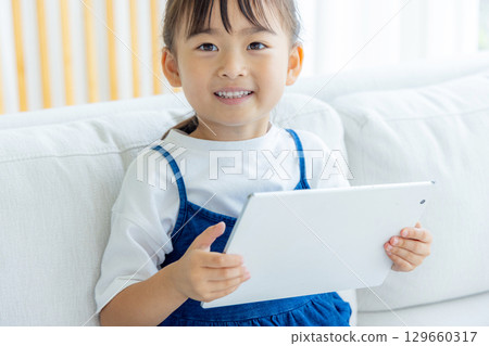 A girl watching a tablet 129660317
