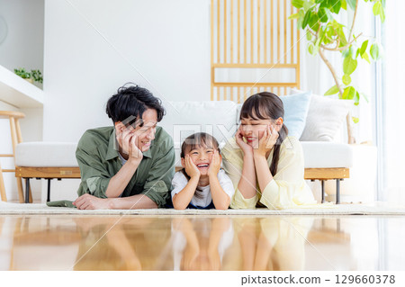A young family relaxing in the living room　 129660378