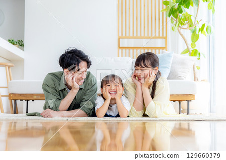 一個在客廳裡放鬆的年輕家庭 129660379