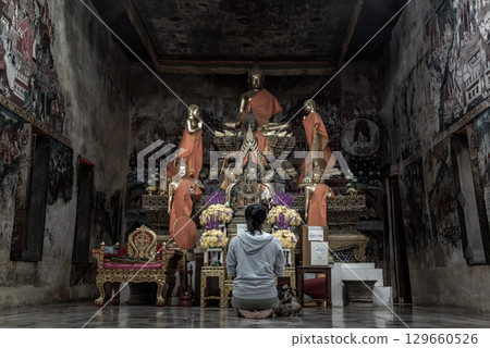 Young woman sitting praying pay respect to Buddha statue in the Wat Kongkharam Rajavaravihara (Photharam) Ratchaburi. Worship pray Young woman sitting praying pay respect to Buddha statue in the Wat Kongkharam Rajavaravihara (Photharam) Ratchaburi. Worship pray 129660526