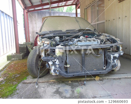 A dilapidated abandoned car 129660693