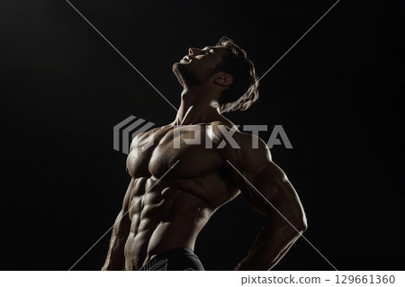 Fitness Model Showcases Strength and Elegance Against a Dark Backdrop. Generative AI 129661360