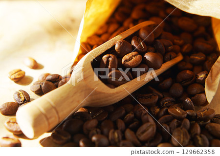 Coffee beans in a paper bag and a measuring scoop Coffee beans in a paper bag and a measuring scoop 129662358