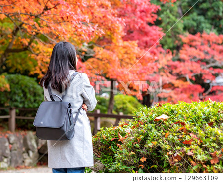 一位女士看著秋葉的背影 129663109