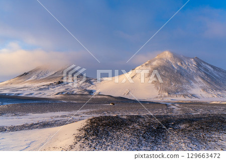 冰島高地的雪山在夕陽下閃閃發光 冰島高地的雪山在夕陽下閃閃發光 129663472