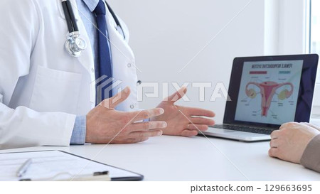 Doctor reviewing digital test results with patient, discussing health findings on laptop screen during clinical consultation. Medicine and health care concept. 129663695