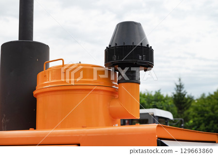 Close-up of an orange industrial air filtration system outdoors. Close-up of an orange industrial air filtration system outdoors. 129663860
