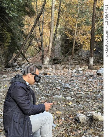 Drone pilot wearing a mask in nature in autumn. High quality photo 129664411