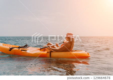 Kayaking, Ocean, Sunset - Woman kayaking on calm ocean water during sunset. 129664678