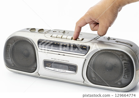 Hand pressing play button on vintage cassette player retro audio equipment silver color isolated on white background nostalgic mood classic music device old technology close up detail Hand pressing play button on vintage cassette player retro audio equipment silver color isolated on white background nostalgic mood classic music device old technology close up detail 129664774