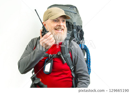 Man with backpack and radio gear prepares for outdoor adventure in nature 129665190