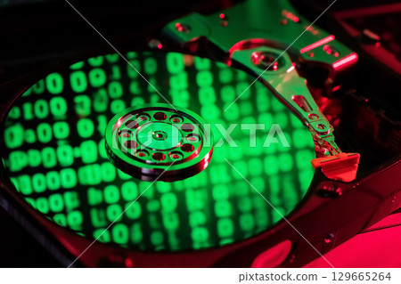 moving hard drive head with green data on drive 129665264