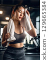 女人在健身房訓練後擦汗 129665384