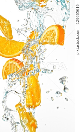 Fresh Orange Slices Falling in Water Splashes, isolated on White Background. Freeze Motion of Fruit Beverages. Fresh Orange Slices Falling in Water Splashes, isolated on White Background. Freeze Motion of Fruit Beverages. 129665616