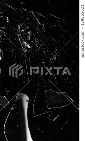 Dirty Glass Broken into a Large Number of Pieces and Parts, a Piece of Glass with a lot of Cracks and Broken Parts. Isolated on Black Background. Dirty Glass Broken into a Large Number of Pieces and Parts, a Piece of Glass with a lot of Cracks and Broken Parts. Isolated on Black Background. 129665621