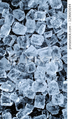 Ice Cubes. Textured Ice on a Black Background, Close-up. Abstract Background, Flying Ice. Vertical Aspect Ratio. 129665644