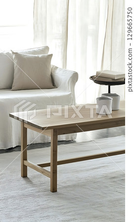 Wooden coffee table sits in front of a white couch 129665750