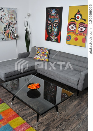 A living room with a gray couch and a black coffee table 129666066