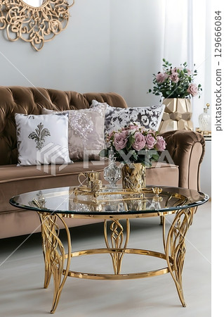 A gold coffee table with a vase of flowers on top 129666084