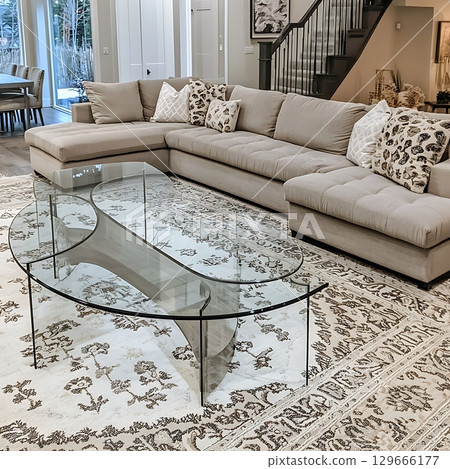 A living room with a glass coffee table and a white couch 129666177