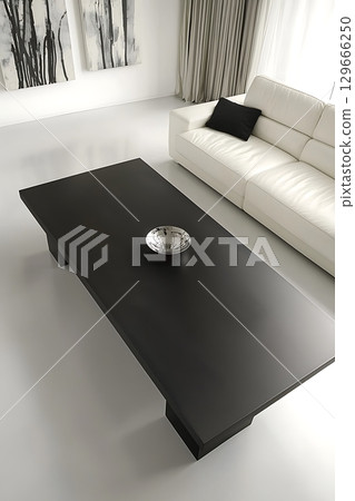 A black coffee table sits in front of a white couch 129666250