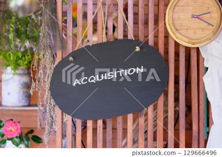 Copy space. Attraction of investments concept. ACQUISITION word written on a decorative wooden board 129666496