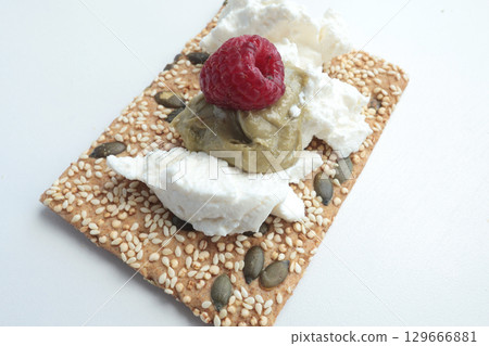 Crispy grain breads with seeds, cheese, ricotta and berries, marmalade. Breakfast and healthy eating. Crispy grain breads with seeds, cheese, ricotta and berries, marmalade. Breakfast and healthy eating. 129666881