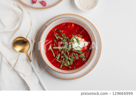 Traditional Ukrainian borscht with sour cream, garlic and rye bread on white table. Top view 129668999