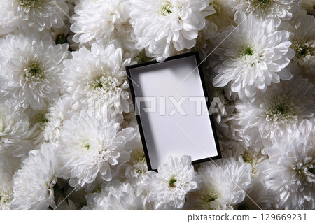 Black funeral frame with white chrysanthemums in a solemn hyper-real tribute scene 129669231