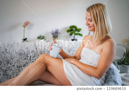 Woman using portable laser hair removal device at home 129669610
