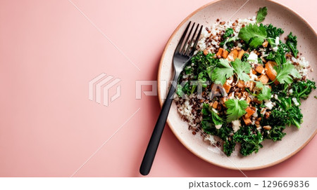 Colorful vegetarian salad with quinoa, kale, and roasted vegetables on a pink background 129669836