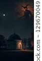 Dark atmospheric scene with a mysterious figure looming over a small chapel at night 129670049