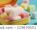 Colorful sugar cubes in a yellow tin container highlighting the harmful effects of sugar consumption 129670052
