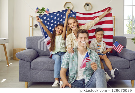 Portrait of happy young American family with children who are holding national flags. Portrait of happy young American family with children who are holding national flags. 129670059